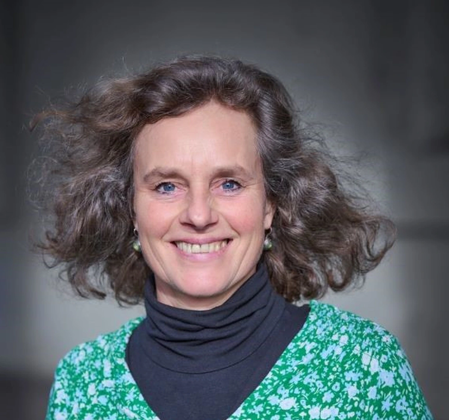 Porträt von Natascha Schreiber vor grauem Studiohintergrund.